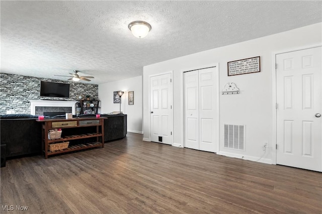 3990 Abigail Dr, Lorain, OH 44053 - living room with ceiling fan, wood finished floors, a textured ceiling, and a tiled fireplace