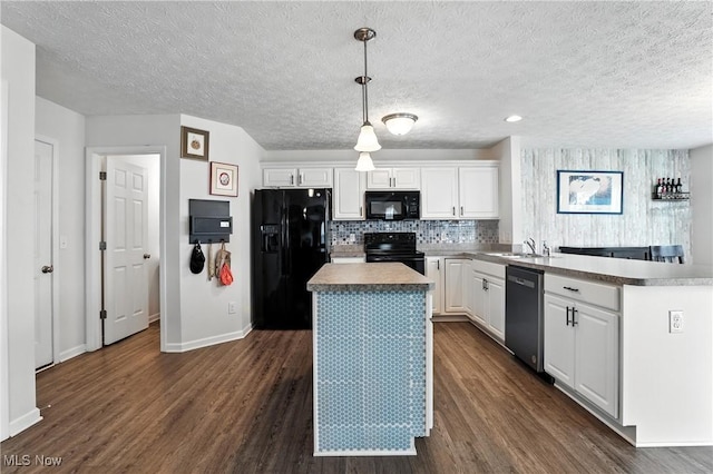 3990 Abigail Dr, Lorain, OH 44053 - kitchen featuring black appliances, dark wood finished floors, a center island, white cabinetry, and a textured ceiling