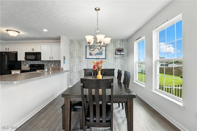 3990 Abigail Dr, Lorain, OH 44053 - dining area with dark wood-style flooring, a chandelier, and a textured ceiling
