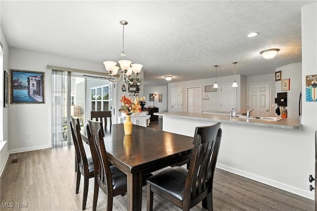 3990 Abigail Dr, Lorain, OH 44053 - dining area featuring wood finished floors, a chandelier, and a textured ceiling