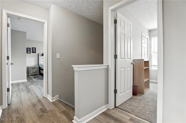 3990 Abigail Dr, Lorain, OH 44053 - hallway featuring wood finished floors, a textured ceiling, and an upstairs landing
