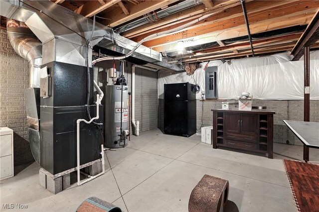 3990 Abigail Dr, Lorain, OH 44053 - unfinished basement with water heater, freestanding refrigerator, heating unit, electric panel, and brick wall