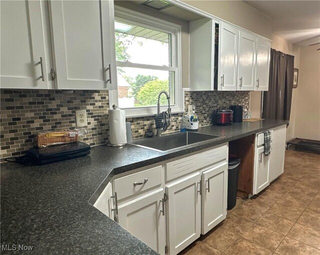 344 17th St NW, Barberton, OH 44203 - kitchen featuring white cabinets, backsplash, tile patterned floors, and dark countertops