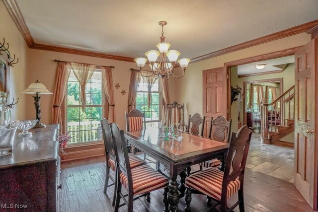 3020 Crookston Ln, Clinton, OH 44216 - dining area featuring a chandelier, healthy amount of natural light, hardwood / wood-style floors, stairs, and crown molding