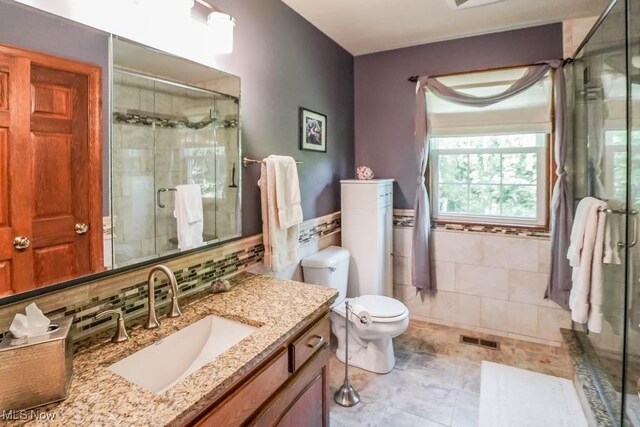 3020 Crookston Ln, Clinton, OH 44216 - bathroom with tile walls, a shower stall, vanity, a wainscoted wall, and tile patterned flooring