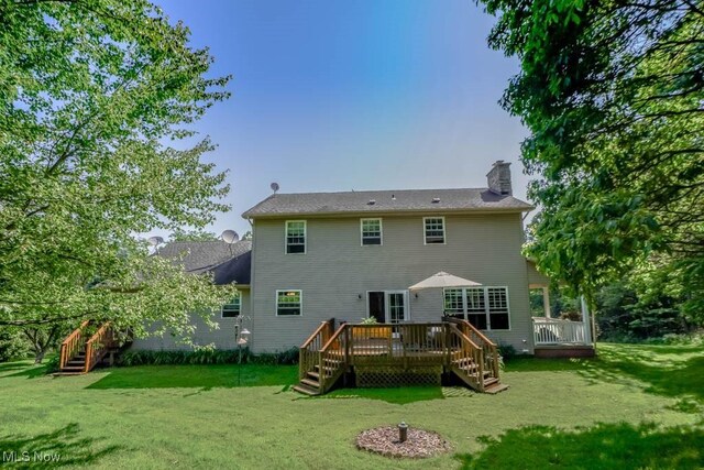 3020 Crookston Ln, Clinton, OH 44216 - back of property with a chimney, a lawn, a wooden deck, and stairs