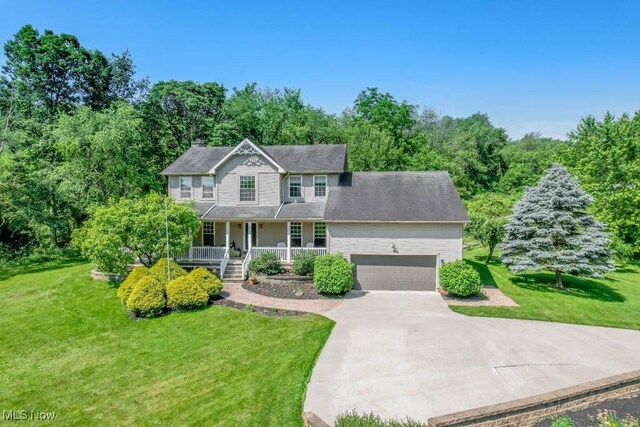 3020 Crookston Ln, Clinton, OH 44216 - colonial-style house with a porch, a front yard, an attached garage, and concrete driveway