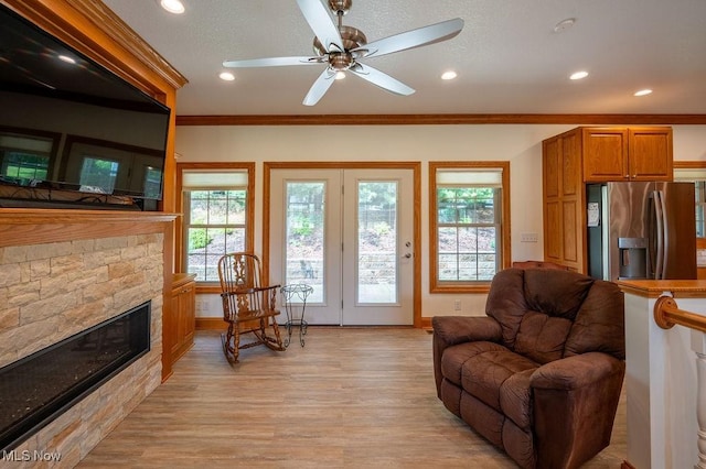 116 Falling Waters Dr, Vienna, WV 26105 - living room with light wood-type flooring, a stone fireplace, recessed lighting, ceiling fan, and ornamental molding