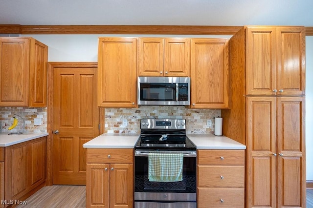 116 Falling Waters Dr, Vienna, WV 26105 - kitchen with stainless steel appliances, light countertops, backsplash, light wood-style floors, and brown cabinets