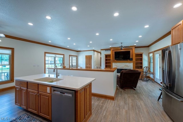 116 Falling Waters Dr, Vienna, WV 26105 - kitchen with stainless steel appliances, ceiling fan, an island with sink, light wood-style floors, and ornamental molding