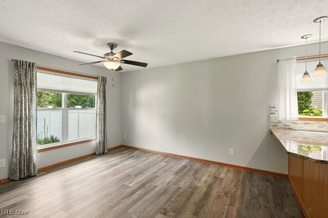 1367 Hidden Lake Blvd, Akron, OH 44312 - unfurnished room featuring wood finished floors, plenty of natural light, ceiling fan, and a textured ceiling