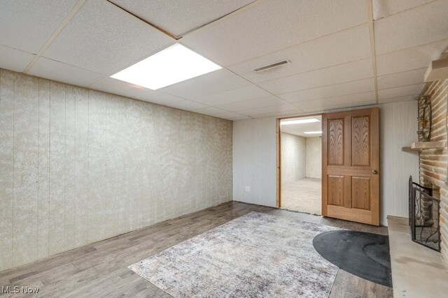 1260 Pleasant Ridge St SE, Minerva, OH 44657 - finished basement featuring a paneled ceiling, wood finished floors, a brick fireplace, and wooden walls