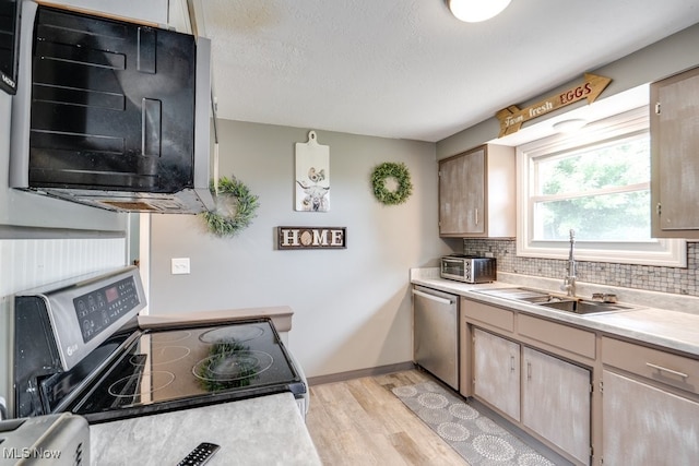 1260 Pleasant Ridge St SE, Minerva, OH 44657 - kitchen featuring stainless steel appliances, light wood-type flooring, decorative backsplash, light countertops, and a textured ceiling