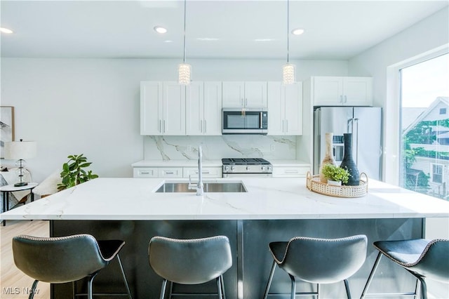 1369 W 74th St, Cleveland, OH 44102 - kitchen featuring appliances with stainless steel finishes, white cabinetry, a breakfast bar, backsplash, and recessed lighting
