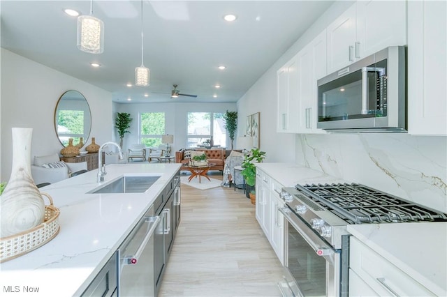 1369 W 74th St, Cleveland, OH 44102 - kitchen with stainless steel appliances, recessed lighting, ceiling fan, light stone countertops, and white cabinetry