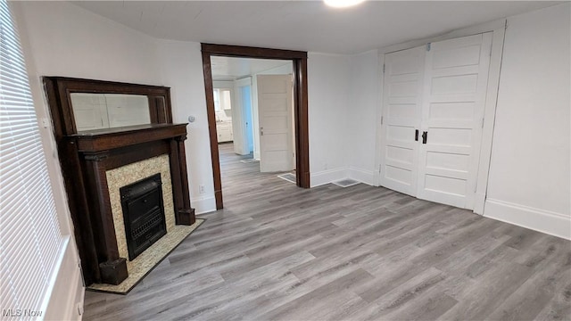 916 6th St NW, Canton, OH 44703 - unfurnished living room with light wood-type flooring and a fireplace with flush hearth