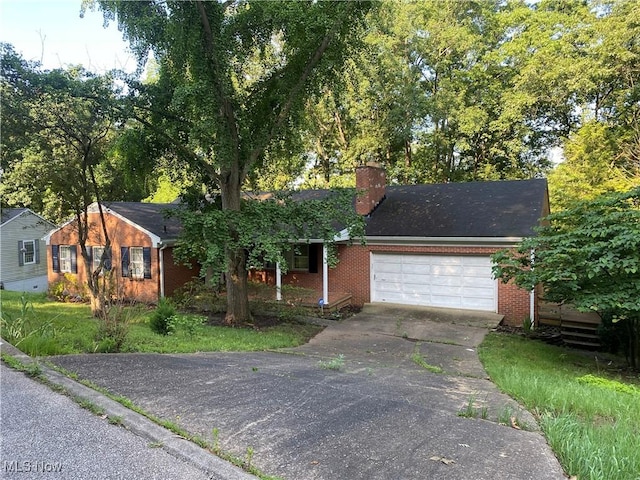 14 Woodland Park Dr, Parkersburg, WV 26104 - view of front facade with brick siding, driveway, a chimney, and a garage