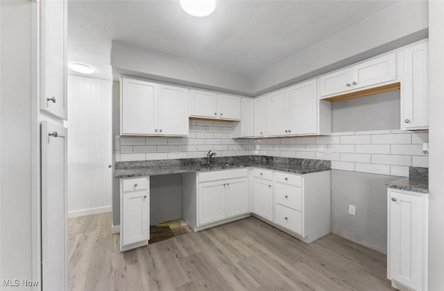 5318 Pinecrest Ave, Youngstown, OH 44515 - kitchen featuring light wood-style floors, decorative backsplash, and white cabinetry