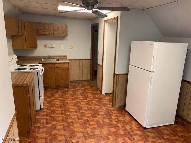 1543 Genesee Rd, South Euclid, OH 44121 - kitchen with white appliances, wainscoting, ceiling fan, brown cabinets, and vaulted ceiling