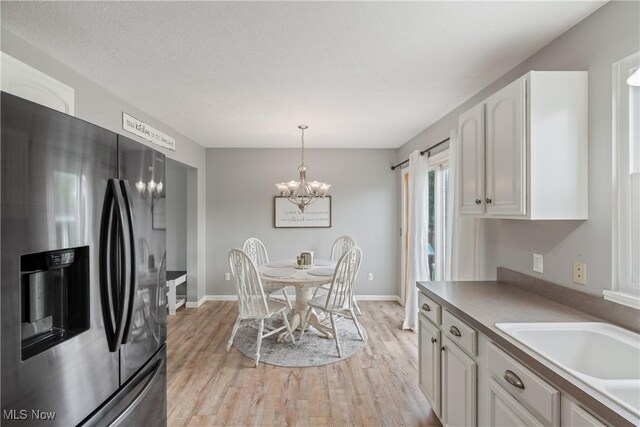 7287 Fayette Blvd, Chippewa Lake, OH 44215 - dining space featuring a chandelier and light wood-style floors