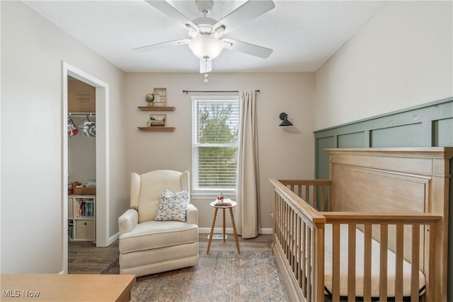 7287 Fayette Blvd, Chippewa Lake, OH 44215 - bedroom with wood finished floors, a crib, a closet, a ceiling fan, and a walk in closet