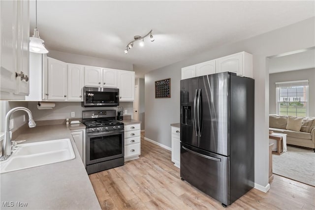 7287 Fayette Blvd, Chippewa Lake, OH 44215 - kitchen featuring stainless steel appliances, white cabinets, light wood-type flooring, and light countertops