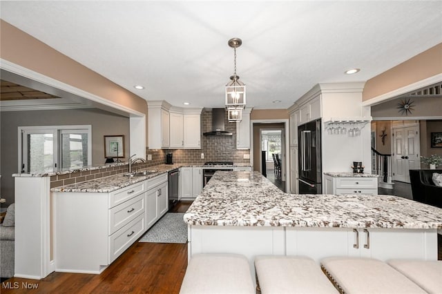 5277 Foxchase Ave NW, Canton, OH 44718 - kitchen featuring wall chimney range hood, appliances with stainless steel finishes, dark wood-type flooring, healthy amount of natural light, and recessed lighting