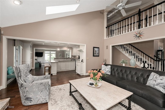5277 Foxchase Ave NW, Canton, OH 44718 - living area featuring a skylight, dark wood-style floors, high vaulted ceiling, a ceiling fan, and stairs