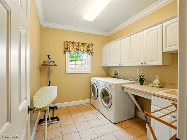 4440 Rutledge Ave, Ashtabula, OH 44004 - washroom featuring cabinet space, washer and clothes dryer, crown molding, and light tile patterned floors