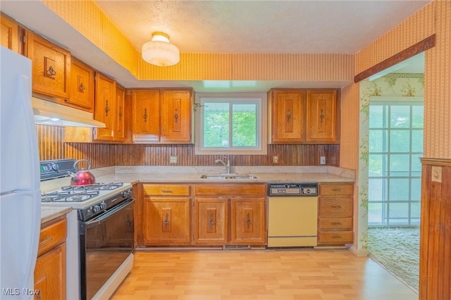 34112 Chagrin Blvd Unit 7106, Moreland Hills, OH 44022 - kitchen with white appliances, wallpapered walls, light countertops, light wood-style floors, and brown cabinets
