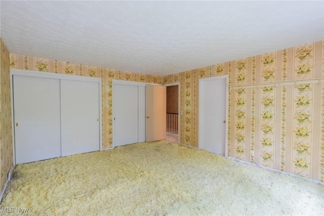 34112 Chagrin Blvd Unit 7106, Moreland Hills, OH 44022 - unfurnished bedroom with wallpapered walls, two closets, and carpet floors