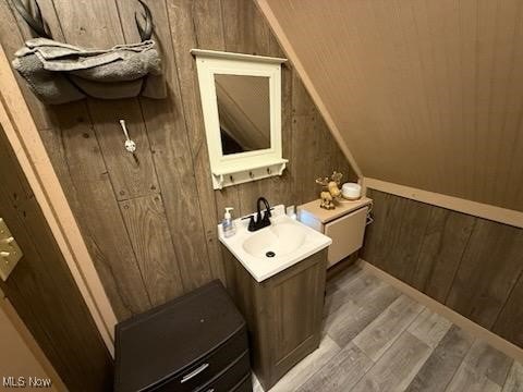 2461 Trailwood Dr SW, Carrollton, OH 44615 - bathroom featuring wood walls, wood finished floors, vanity, and vaulted ceiling