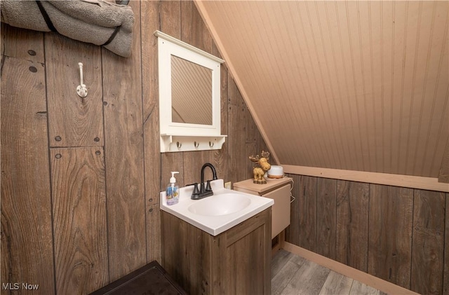 2461 Trailwood Dr SW, Carrollton, OH 44615 - half bathroom with lofted ceiling, wood finished floors, vanity, and wooden walls