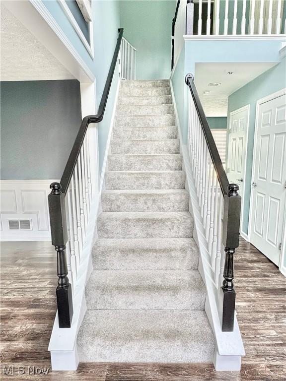11208 Glen Abbey Dr, North Royalton, OH 44133 - staircase with wood finished floors and a towering ceiling
