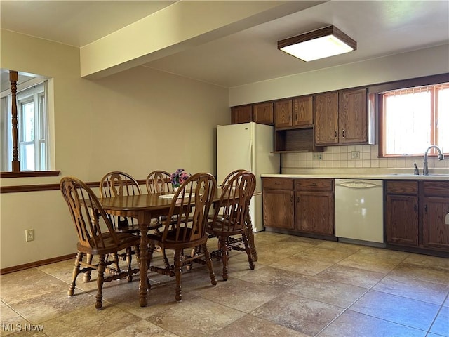 145 Marcia Dr, Austintown, OH 44515 - kitchen featuring white appliances, backsplash, light countertops, dark brown cabinetry, and light stone finish flooring