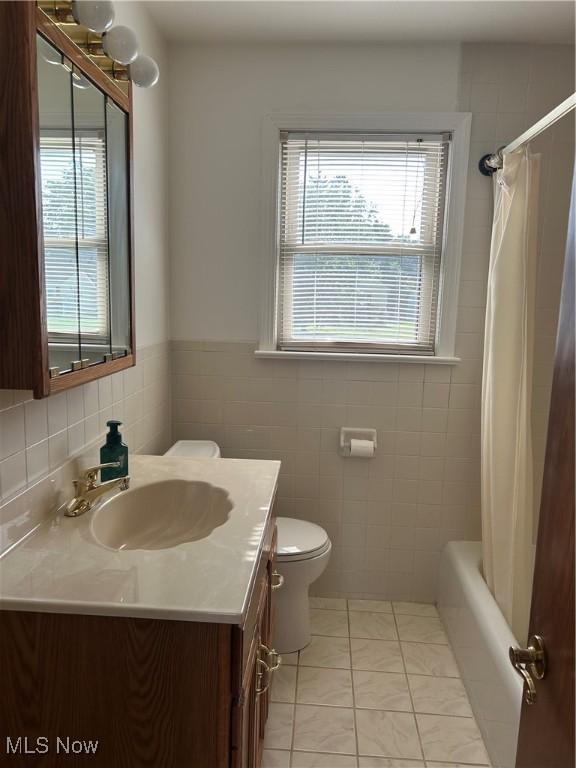 145 Marcia Dr, Austintown, OH 44515 - bathroom with vanity, tile walls, and shower / bath combo with shower curtain