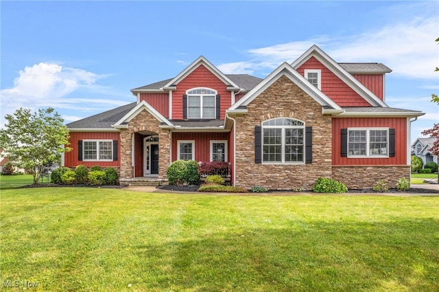 2940 Londonbury St NW, Uniontown, OH 44685 - craftsman-style house featuring stone siding, board and batten siding, a front yard, and roof with shingles