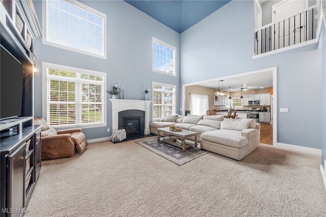 2940 Londonbury St NW, Uniontown, OH 44685 - carpeted living area featuring a high ceiling and a fireplace with flush hearth