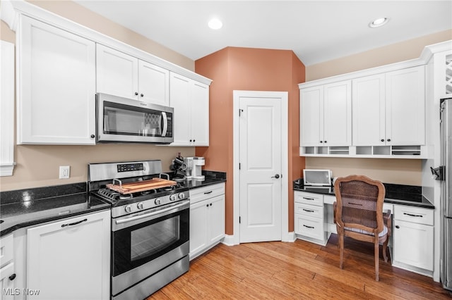 2940 Londonbury St NW, Uniontown, OH 44685 - kitchen featuring appliances with stainless steel finishes, built in desk, white cabinets, light wood-type flooring, and recessed lighting