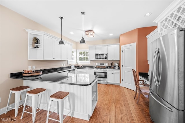 2940 Londonbury St NW, Uniontown, OH 44685 - kitchen featuring appliances with stainless steel finishes, open shelves, a peninsula, white cabinets, and recessed lighting