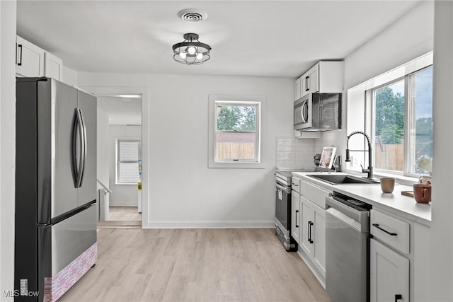 85 Pocantico Ave, Akron, OH 44312 - kitchen with stainless steel appliances, light wood-type flooring, light countertops, and white cabinetry