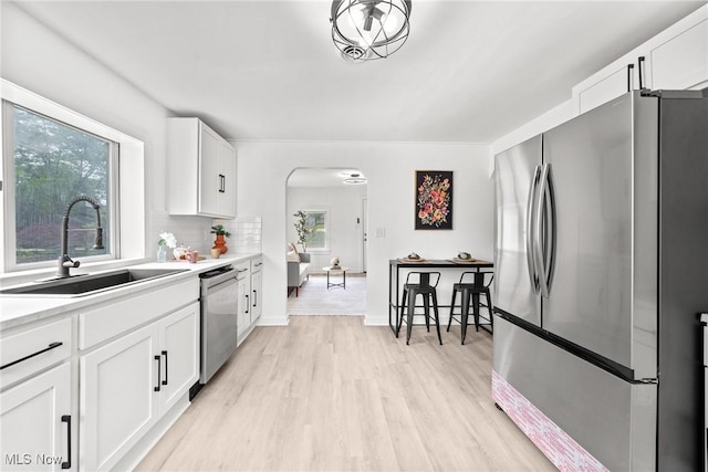 85 Pocantico Ave, Akron, OH 44312 - kitchen featuring appliances with stainless steel finishes, arched walkways, light wood finished floors, light countertops, and white cabinetry