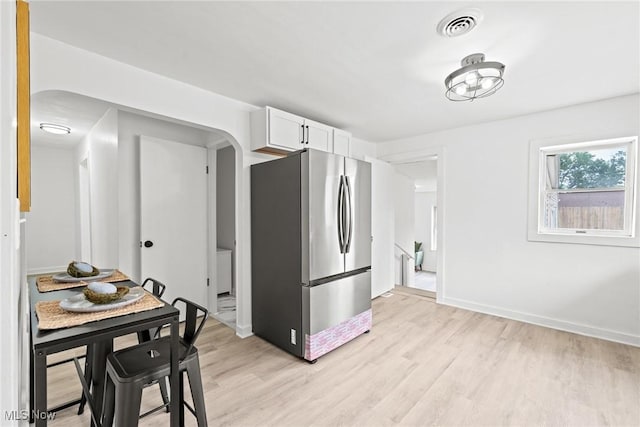 85 Pocantico Ave, Akron, OH 44312 - kitchen featuring freestanding refrigerator, light wood-style floors, white cabinets, and arched walkways