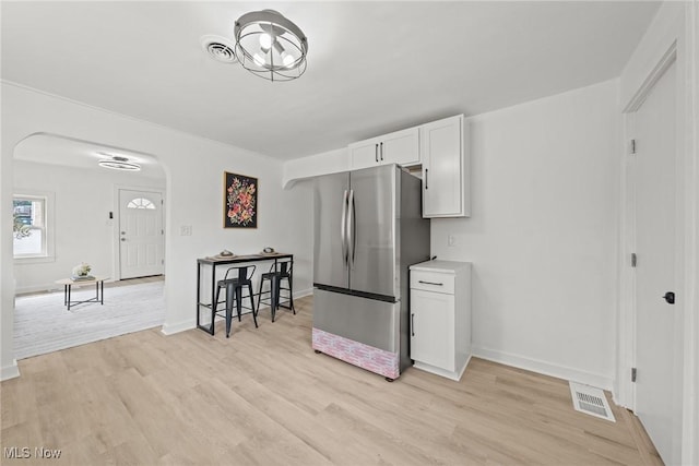 85 Pocantico Ave, Akron, OH 44312 - kitchen featuring freestanding refrigerator, arched walkways, light wood-type flooring, and white cabinets