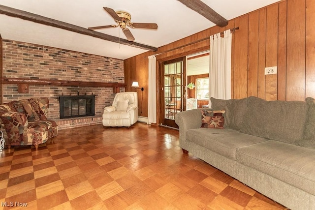 13228 Boulder, Chesterland, OH 44026 - living room featuring wooden walls, beamed ceiling, tile patterned floors, a ceiling fan, and a brick fireplace