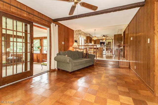 13228 Boulder, Chesterland, OH 44026 - living area featuring a ceiling fan, wooden walls, beam ceiling, and tile patterned floors