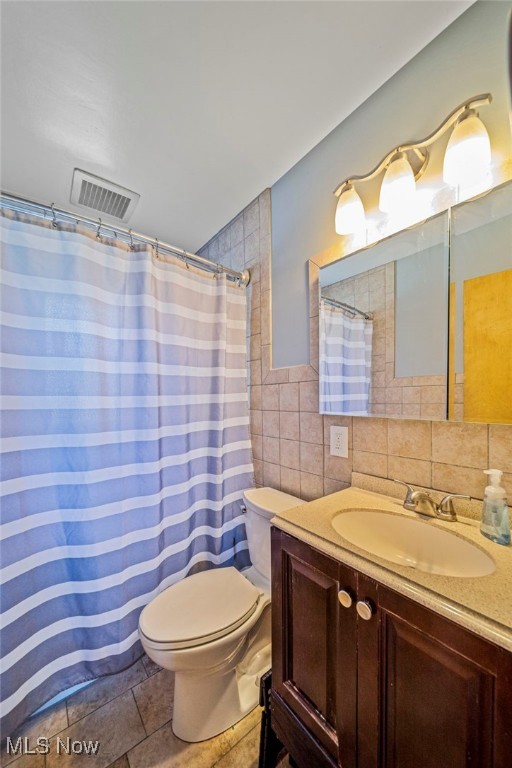 28666 Forest Rd, Willowick, OH 44095 - bathroom featuring tile walls, vanity, and a shower with curtain