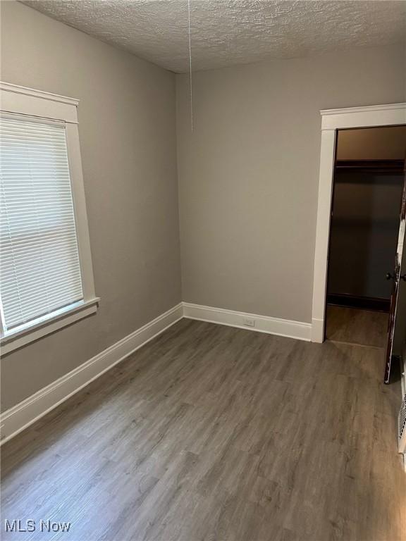 1114 E 64th St, Cleveland, OH 44103 - empty room featuring a textured ceiling and dark wood-type flooring