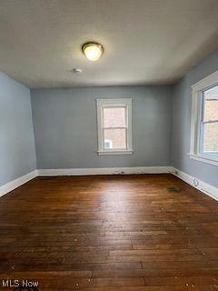 1114 E 64th St, Cleveland, OH 44103 - spare room with baseboards and wood-type flooring