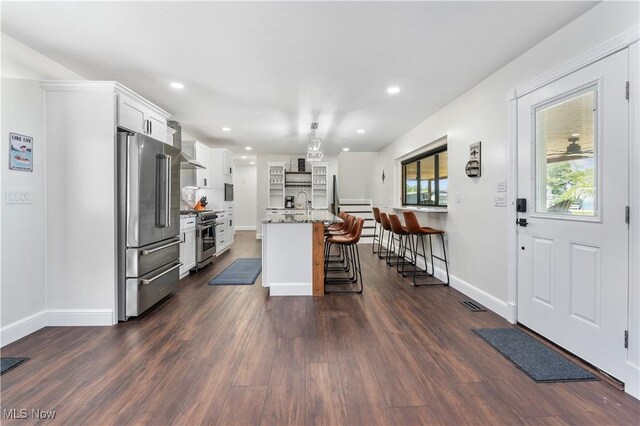 5111 N Myers Rd, Geneva, OH 44041 - kitchen featuring high quality appliances, a kitchen breakfast bar, white cabinetry, dark wood-style floors, and recessed lighting